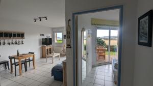 a room with a kitchen and a dining room with a table at Appartement T2, RDJ, 2 étoiles, Vue mer panoramique, Côte de Granit Rose in Perros-Guirec