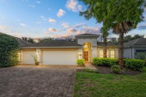 a house with a garage and a palm tree at Nocatee Retreat with Fenced Yard & Lanai in Sampson