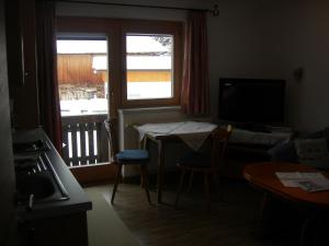 a living room with a small table and a window at Haus Mooshof in Lermoos