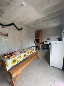 a kitchen with a table and a refrigerator at Residencial Chalés Riviera in Matinhos