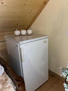 a small white refrigerator in a room with a ceiling at Riza Guest House in Pukë