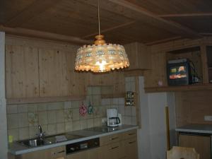 a chandelier hanging in a kitchen with a sink at Haus Mooshof in Lermoos