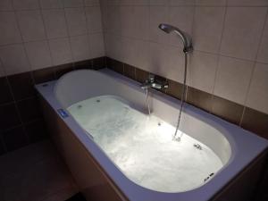 a bath tub with a faucet with water in it at Maison des Fées d'Achouffe in Houffalize +18 photos