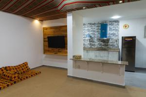 a room with a couch and a kitchen with a refrigerator at Beach Chalet - 10 in Al Ḩadd +5 photos