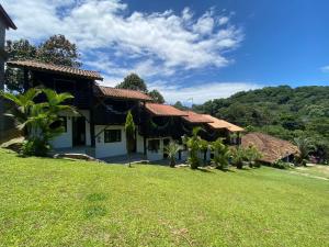 a house with a green lawn in front of it at Pousada Vale da Praia in Praia do Rosa