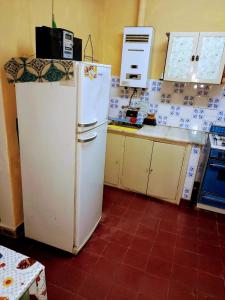 a kitchen with a white refrigerator in a room at Huerta grande in Huerta Grande