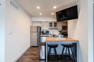 a kitchen with a counter with stools and a refrigerator at MedCenter Apt Studio-NRG Prox in Houston