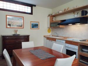 a kitchen with a wooden table and white chairs at Masaya house in Ronciglione