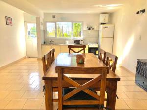 a kitchen with a wooden table and a refrigerator at El Retiro CASA 3 DORMITORIOS in Villa El Chocón +4 photos