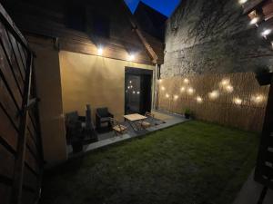 un cortile con tavolo, sedie e luci di Art des sens - SPA et Sauna privatifs a Boulogne-sur-Mer