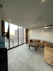 a living room with a couch and a tv at Sense Luxury II - 2 bed Apartment in Islamabad
