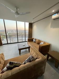 a living room with a couch and a large window at Sense Luxury II - 2 bed Apartment in Islamabad