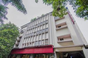 a large white building with a red awning at Collection O MG Guest House in Kolkata