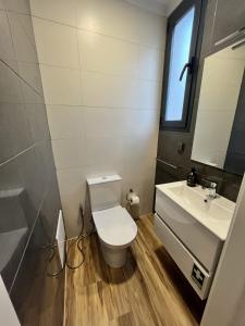 a bathroom with a toilet and a sink at Private 1 bedroom house in Machico Centre in Machico +2 photos