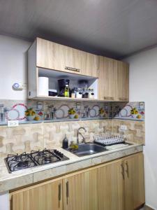 a kitchen with a sink and a stove at Denier House Guabinal Apto 2 41-60 AV GUABINAL in Ibagué +4 photos