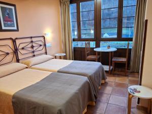 a hotel room with two beds and a window at La Corona del Auteiro in Valle de Lago
