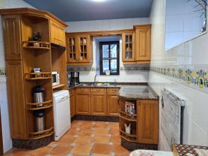 a kitchen with wooden cabinets and a counter top at La Corona del Auteiro in Valle de Lago