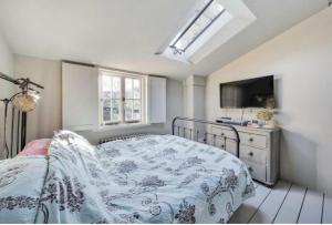 a bedroom with a bed and a television in it at Charming Dulwich Cottage in West Dulwich