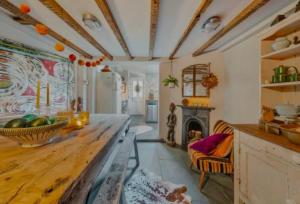 a living room with a table and a fireplace at Charming Dulwich Cottage in West Dulwich