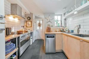 a large kitchen with a sink and a stove at Charming Dulwich Cottage in West Dulwich +4 photos