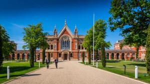 a large brick building with two people standing in front of it at Charming Dulwich Cottage in West Dulwich