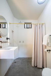 un bagno con lavandino e tenda da doccia di Casa Lumos - Minimalist Comfort Suites in Centro Historico a Città di Oaxaca Altre 58 foto