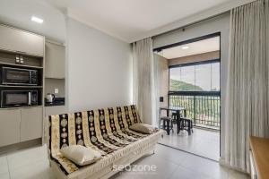 Una sala de estar con un sofá y un balcón. en Apto 2H c/ parrilla a 750m de la playa RVN2003, en Itapema