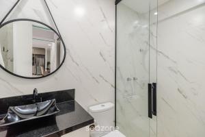 Un baño con ducha, lavabo y espejo. en Apto 2H c/ parrilla a 750m de la playa RVN2003, en Itapema 14 fotos más