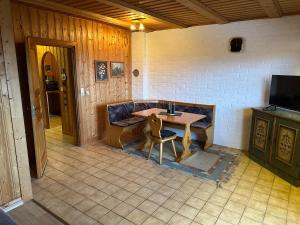 ein Tisch und ein Stuhl in einem Zimmer mit einem Fernseher in der Unterkunft Uriges Apartment + Schönblick + mitten im Bayerischen Wald + WLAN kostenfrei in Schöfweg