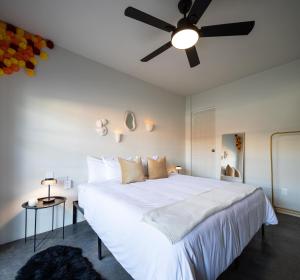 una camera da letto con un grande letto bianco e un ventilatore a soffitto di Casa Lumos - Minimalist Comfort Suites in Centro Historico a Città di Oaxaca