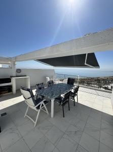 une table et des chaises sur une terrasse avec vue sur l'océan dans l'établissement Infinity View Penthouse Apartment, à Arenales del Sol