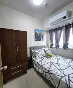 a bedroom with a bed and a dresser and window at Coast Residences - 1 Bedroom with Balcony near PICC, WTC, Star City & MOA in Manila