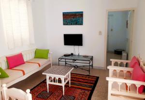 a living room with a couch and a tv at Dar Dalenda in Mezraya