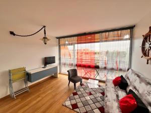 Heliotel Marine Studio avec balcon au 4eme étage à 200m de la mer في سان لوران دو فار: غرفة معيشة مع أريكة وكرسي