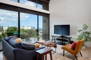 a living room with a couch and a flat screen tv at Stylish Maui Loft Split AC Ocean Views Lanai in Kihei