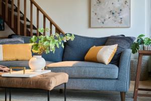 a blue couch in a living room with a table at Stylish Maui Loft Split AC Ocean Views Lanai in Kihei