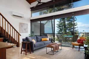 a living room with a blue couch and sliding glass doors at Stylish Maui Loft Split AC Ocean Views Lanai in Kihei +18 photos