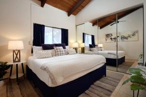 a bedroom with a large bed and a mirror at Stylish Maui Loft Split AC Ocean Views Lanai in Kihei