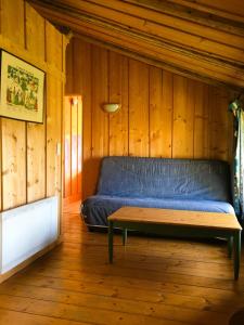 a bed in a wooden room with a bench at Gîte La Petite Grange - En pleine nature ressourcement et randonnée in La Pesse +13 photos