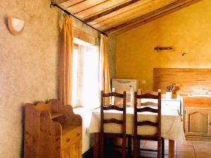 a kitchen with a table and chairs and a window at Gîte La Petite Grange - En pleine nature ressourcement et randonnée in La Pesse