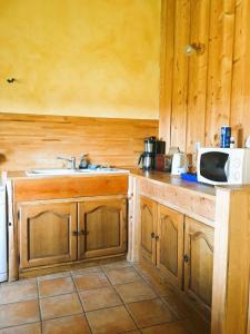 a kitchen with a sink and a microwave at Gîte La Petite Grange - En pleine nature ressourcement et randonnée in La Pesse
