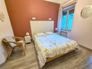 a bedroom with a bed and a chair and a window at La Marquise #Garage#Therme in Royat