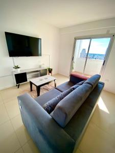 a large couch in a living room with a large window at Departamento PREMIUM in La Plata