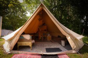 a tent with a bed and a table in it at Glampingtent Camping Namasté in Berlicum