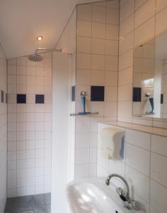 a white bathroom with a sink and a shower at Glampingtent Camping Namasté in Berlicum
