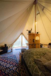a bedroom in a tent with a bed in it at Glampingtent Camping Namasté in Berlicum