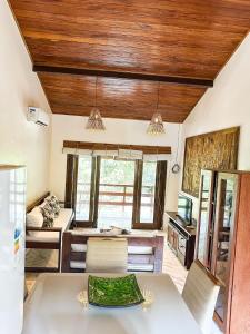 cocina con techos de madera, mesa y sillas en Refúgio Trancoso, en Trancoso