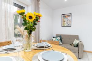 a dining room table with a vase of sunflowers at W deSki dom apartamenty in Krzyżowa