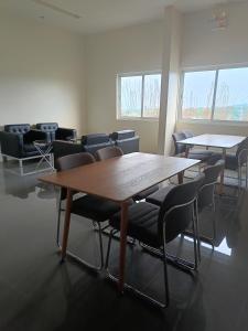 a conference room with tables and chairs and windows at Miranda's Suite by Fullerton in Silang +13 photos