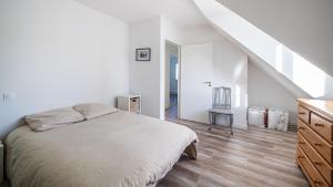 a white bedroom with a bed and a staircase at Ba-Batz Cool - Les Gîtes de la Côte d'Amour in Batz-sur-Mer
